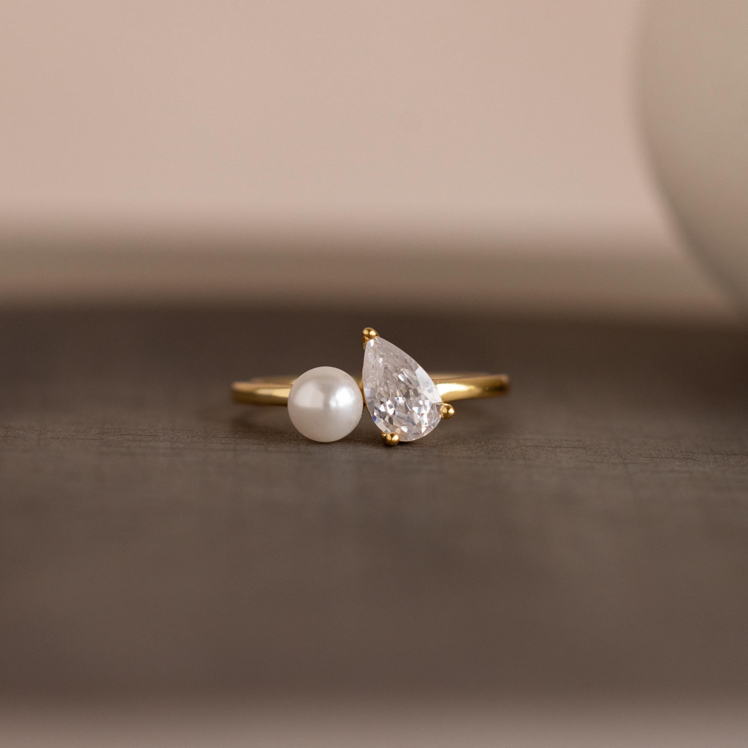 Our Pearl Diamond Ring against a neutral background, focusing on the pearl and diamond setting on the slim gold band.