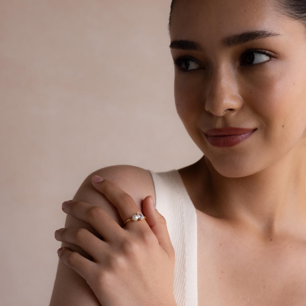 Model wearing the Pearl Diamond Ring, smiling softly while resting her hand on her shoulder, emphasizing the elegant pairing of pearl and diamond.