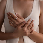 Model’s hands styled with multiple rings, including the Pearl Diamond Ring with pearl and diamond detail, stacked alongside delicate band rings.