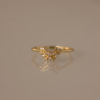 The Diamond Crescent Moon Ring features small sparkling stones and is displayed on a reflective surface—a celestial accessory perfect for adding shimmer to any look.