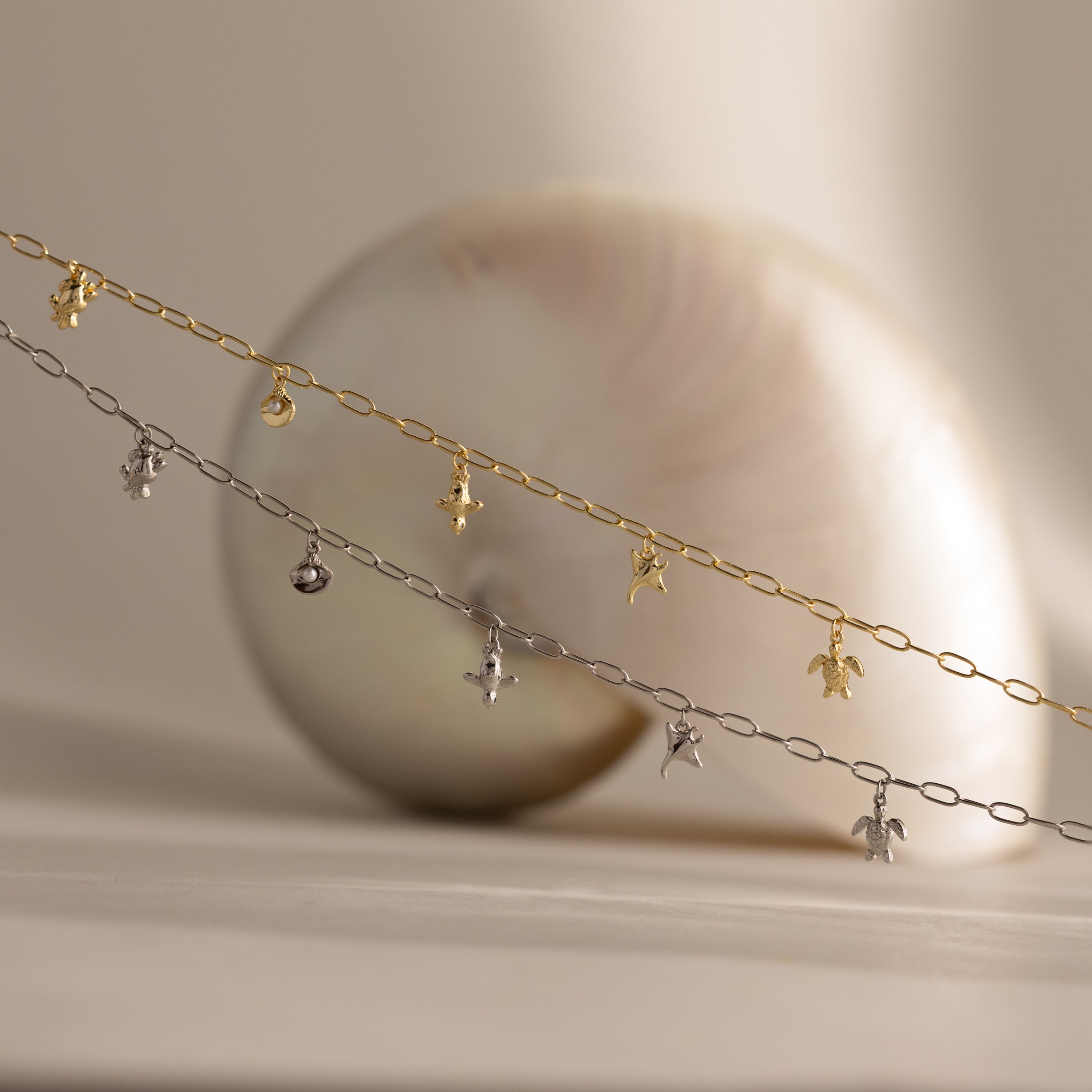 The Seaside Charm Necklace, displayed in front of a seashell on a neutral background, is perfect beach jewelry for adding a touch of coastal elegance.