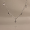 Seaside Charm Necklace in Silver featuring five ocean-themed charms on a plain beige background—perfect beach jewelry or summer accessory.