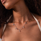 Wearing the Seaside Charm Necklace, this delicate silver piece with small pendants is perfect beach jewelry for effortless summer style.