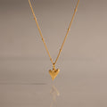 Shark Tooth Necklace in 18K Gold, perfect for coastal jewelry lovers, displayed on a neutral background with its reflection below.