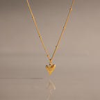 Shark Tooth Necklace in 18K Gold, perfect for coastal jewelry lovers, displayed on a neutral background with its reflection below.