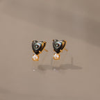 Abalone Pearl Heart Studs in 18K Gold feature heart-shaped abalone, gold accents, and dangling pearls—an elegant piece of coastal jewelry, beautifully displayed on a neutral background.