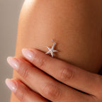Hand with manicured nails holding the Pave Starfish Charm in Silver against bare skin, highlighting this elegant silver starfish jewelry with coastal charm.