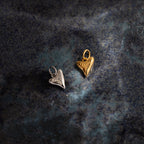 The Dainty Shark Tooth Charm, available in silver and gold heart-shaped pendants, evokes coastal charm—perfect to pair with your favorite beach jewelry.