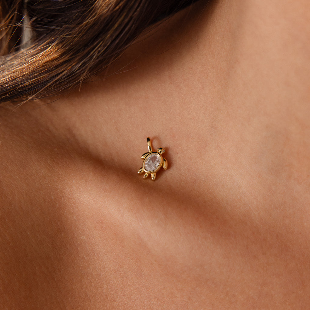 Close-up of the Diamond Turtle Charm in 18K Gold, featuring a clear gemstone and diamond-detailed shell, worn on an earlobe for a stunning ocean-inspired look.