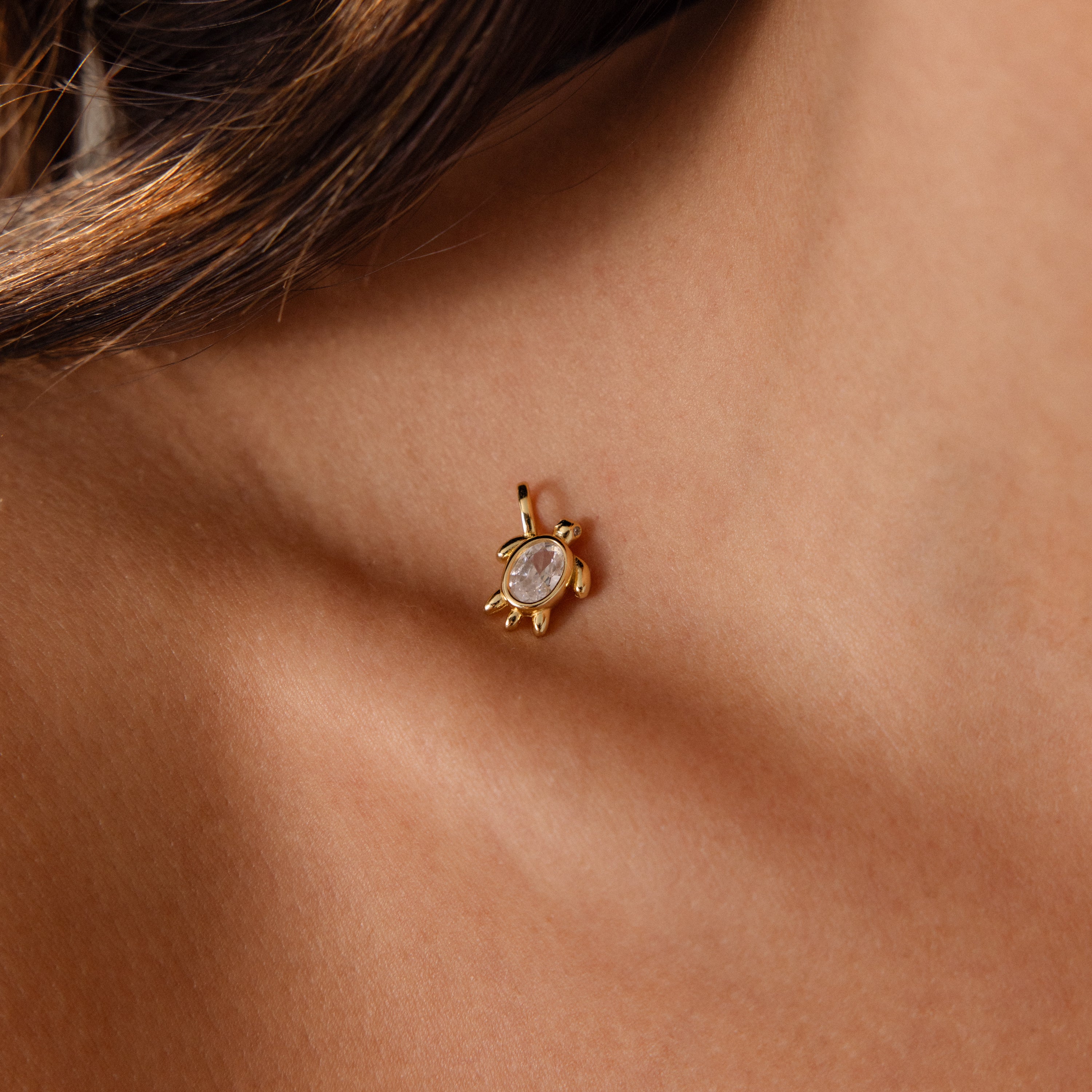 Close-up of the Diamond Turtle Charm in 18K Gold, featuring a clear gemstone and diamond-detailed shell, worn on an earlobe for a stunning ocean-inspired look.