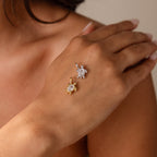 A hand with two Diamond Turtle Charms, one gold and one silver—perfect ocean jewelry for anyone who loves unique turtle-themed accessories.