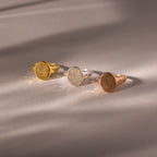 The Organic Fingerprint Signet Ring in Rose Gold is displayed on a smooth, softly lit surface, showcasing its unique fingerprint design as a distinctive piece of jewelry.