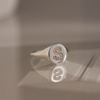 A sterling silver Pave Initial Signet Ring featuring a round top with a crystal-studded "S" on a reflective surface.