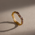 The Staggered Marquise Alexandrite Ring features upright marquise-cut gemstones on a neutral, softly lit surface, offering a unique twist on the classic eternity band.