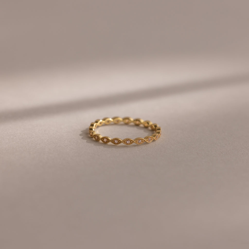 The Dainty Marquise Pink Tourmaline Ring, featuring a delicate gold design and marquise pattern, is showcased on a soft neutral background under gentle lighting.