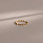 The Dainty Marquise Pink Tourmaline Ring, featuring a delicate gold design and marquise pattern, is showcased on a soft neutral background under gentle lighting.