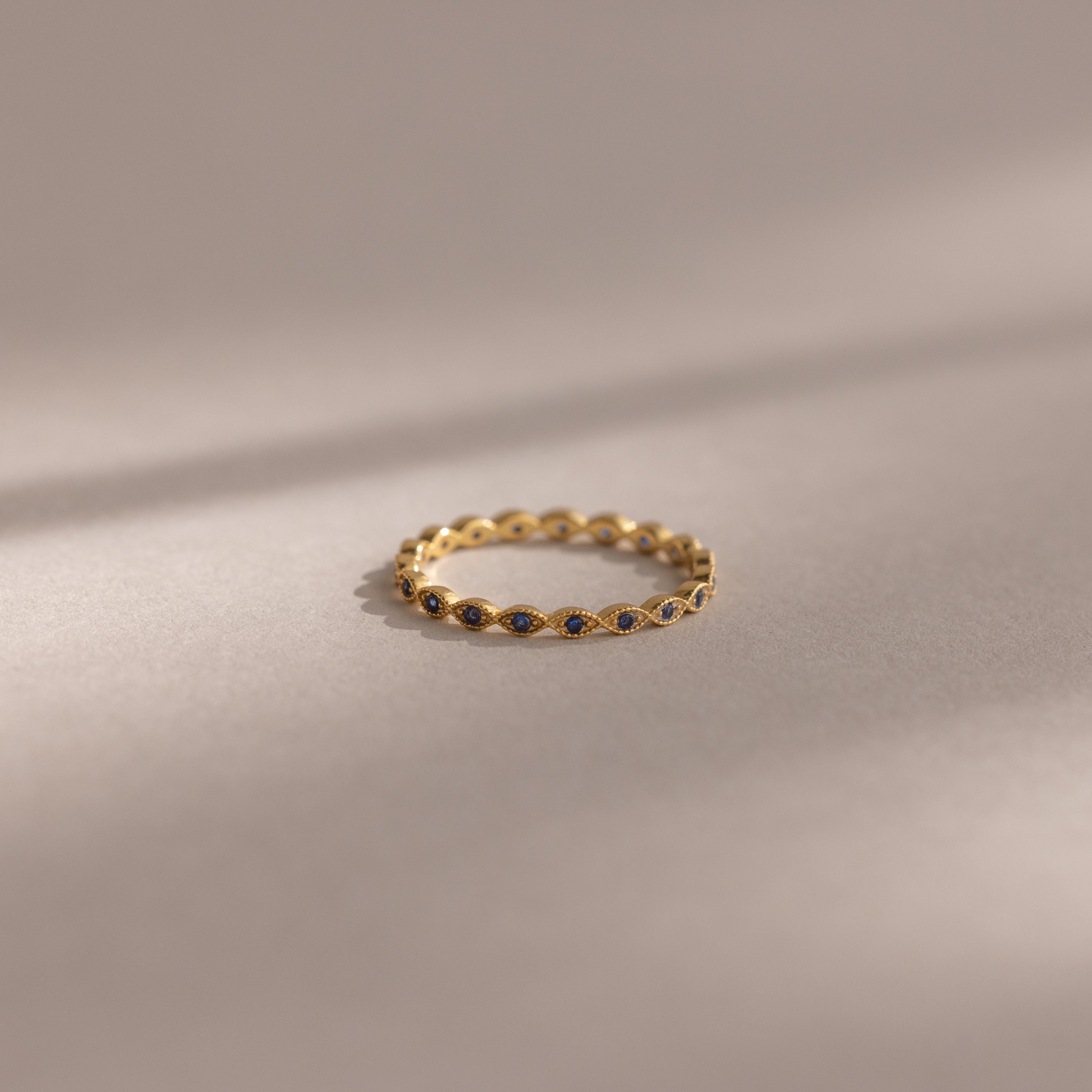 The Dainty Marquise Sapphire Ring showcases small dark sapphires in a marquise pattern, offering a touch of Art Deco elegance.