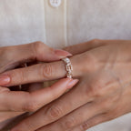 A person wearing the Multiple Name Eternity Ring in Sterling Silver, engraved with custom names, adjusts it on their finger with the other hand.