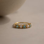 The Birthstone & Pearl Lace Ring in Aquamarine (March) features alternating blue gemstones and pearls on a gold band—an elegant choice for a unique birthstone or pearl ring.