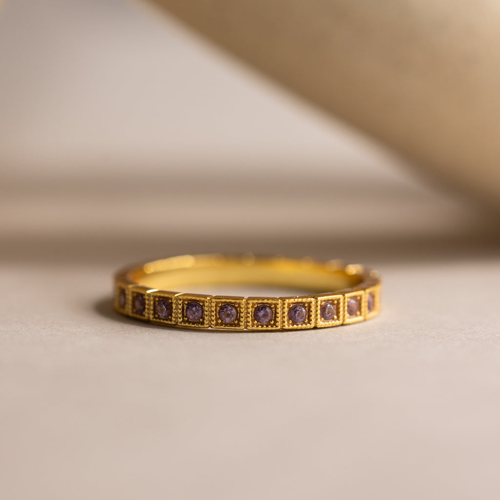 Art Deco Alexandrite Eternity Ring featuring square purple gemstones in a vintage bezel-milgrain setting, displayed on a neutral background.