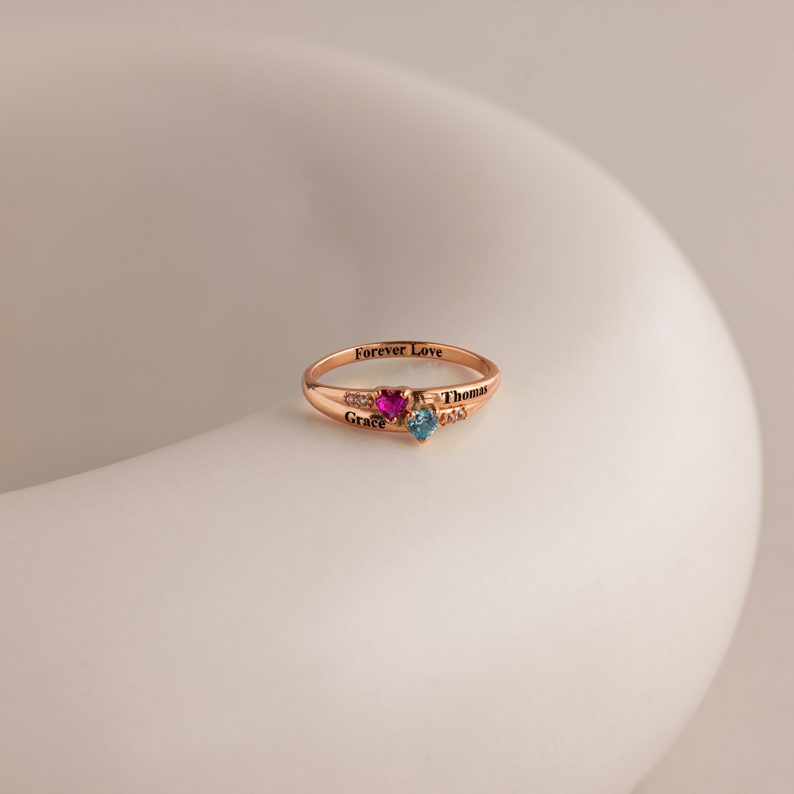 The Toi et Moi Interlocking Name Ring in rose gold features two gemstones and engraved names—Grace, Thomas, and forever love—for a stunning custom design.
