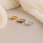 The Toi et Moi Interlocking Name Ring in Rose Gold, personalized with engraved names, is shown displayed on a soft beige fabric background.