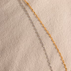 Up-close of a gold and silver mirror chain necklace, showcasing the reflective mirror design.