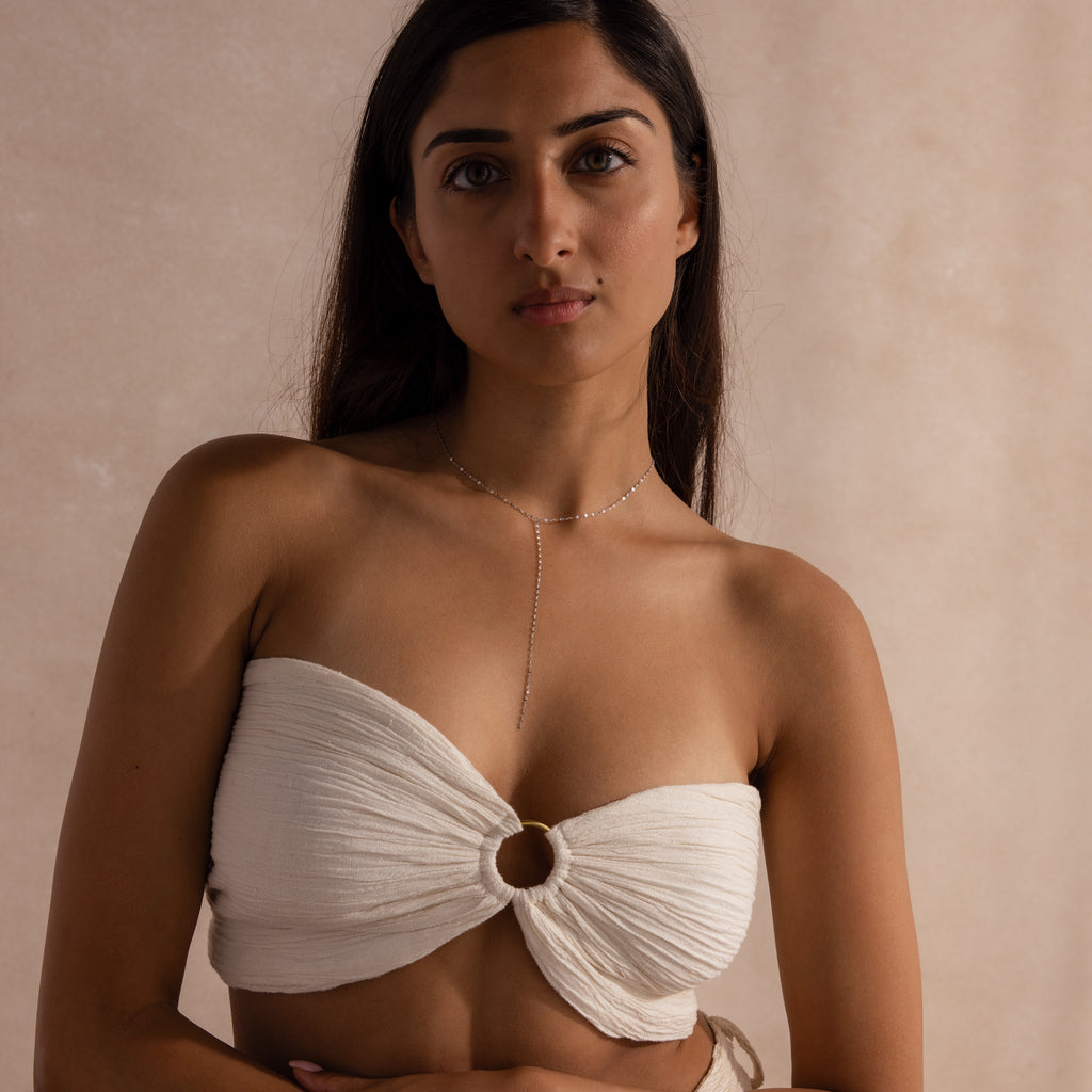 Model wearing a sterling silver dainty mirror chain lariat necklace, styled with a ruched bandeau top.
