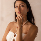 Model wearing a sterling silver hand chain bracelet that connects to a delicate finger loop.
