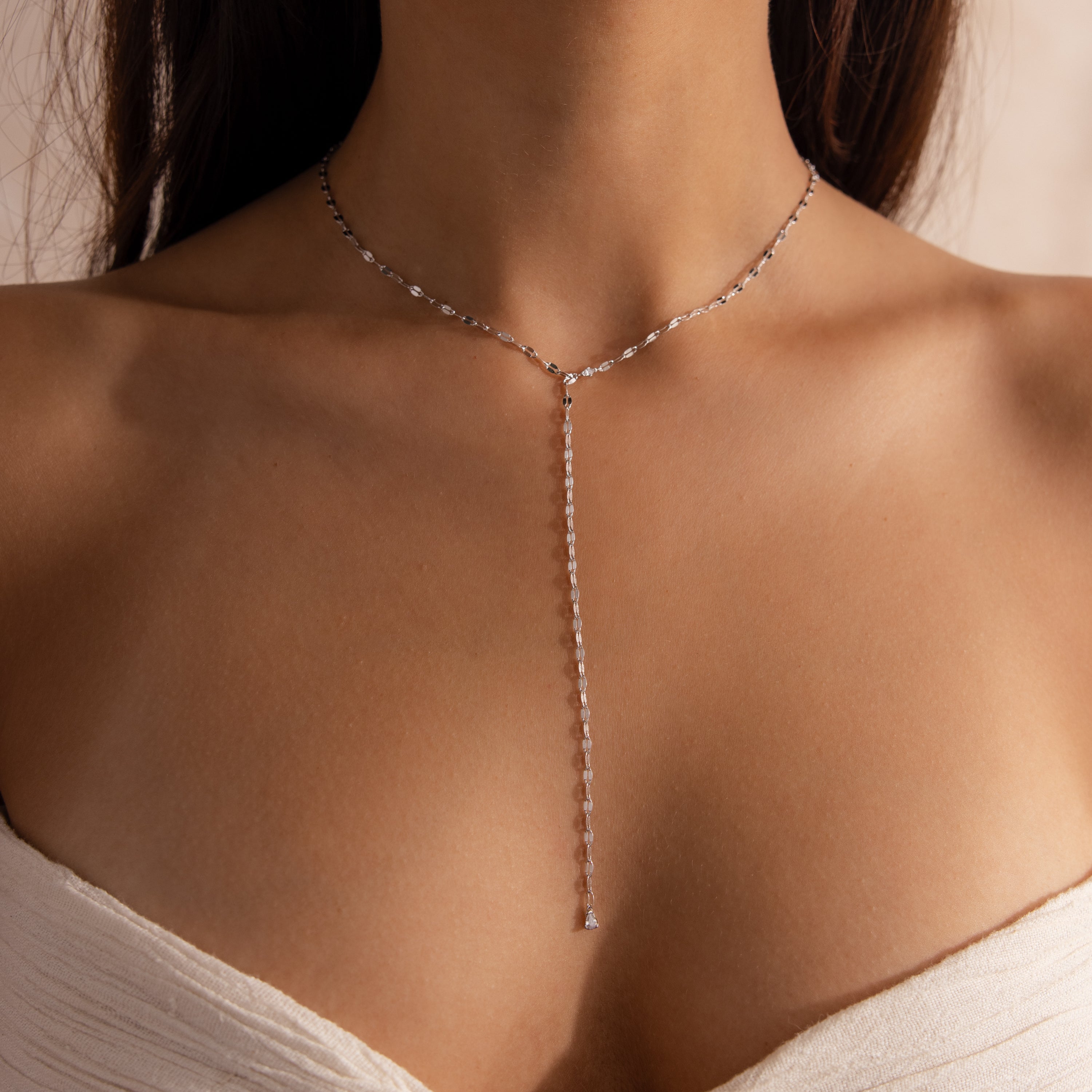 Model wearing a silver dainty Sparkling Diamond Lariat Necklace, which features a delicate mirror chain design with two CZ diamond stones.
