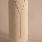 Silver dainty Sparkling Diamond Lariat Necklace with a delicate mirror chain design and two CZ diamond stones, displayed against a ceramic prop.