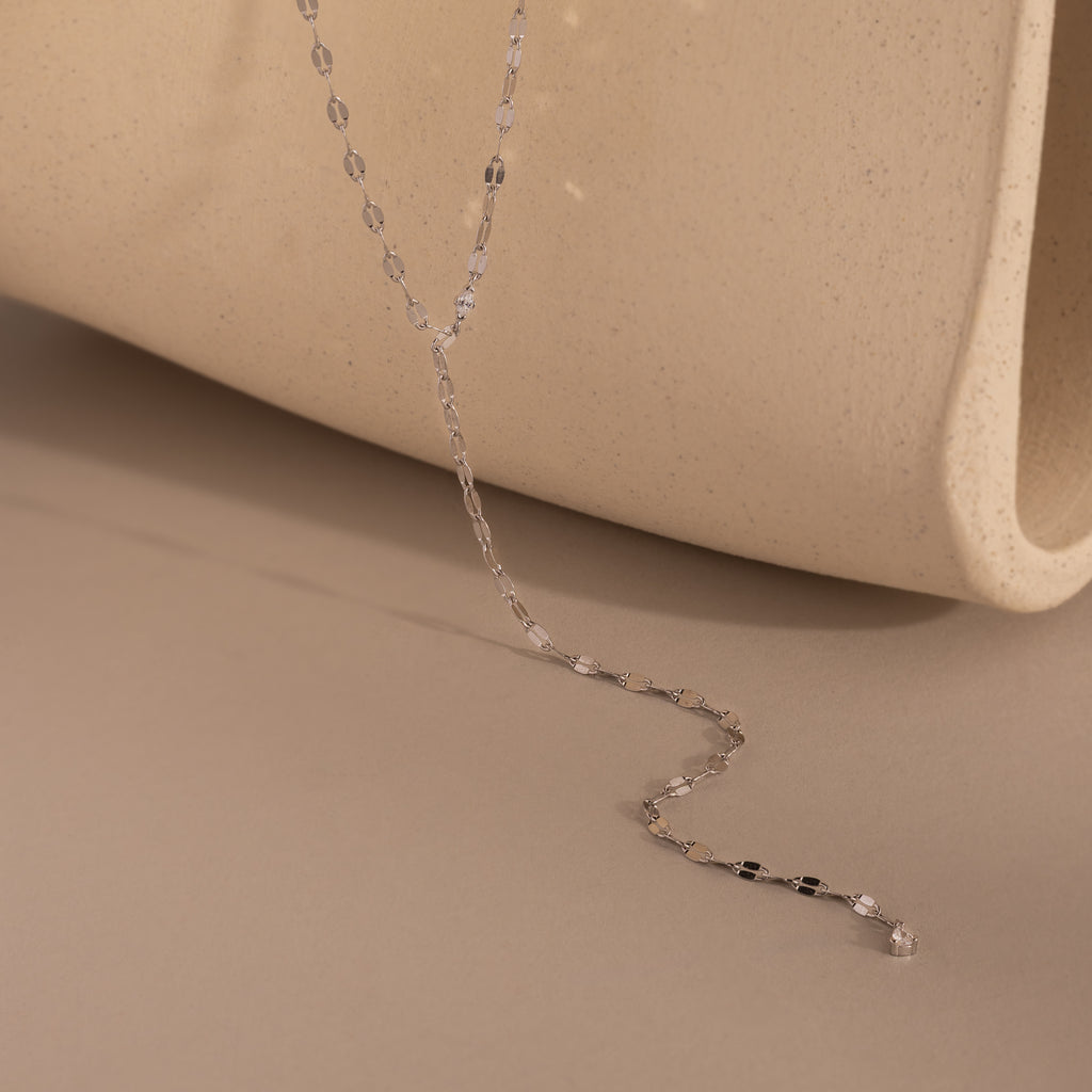 Silver dainty Sparkling Diamond Lariat Necklace with a delicate mirror chain design and two CZ diamond stones, displayed against a neutral-tone backdrop.