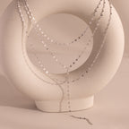 Silver dainty Sparkling Layered Lariat Necklace, featuring 3 layers of mirror chain necklaces in varying lengths, displayed on a ceramic prop.