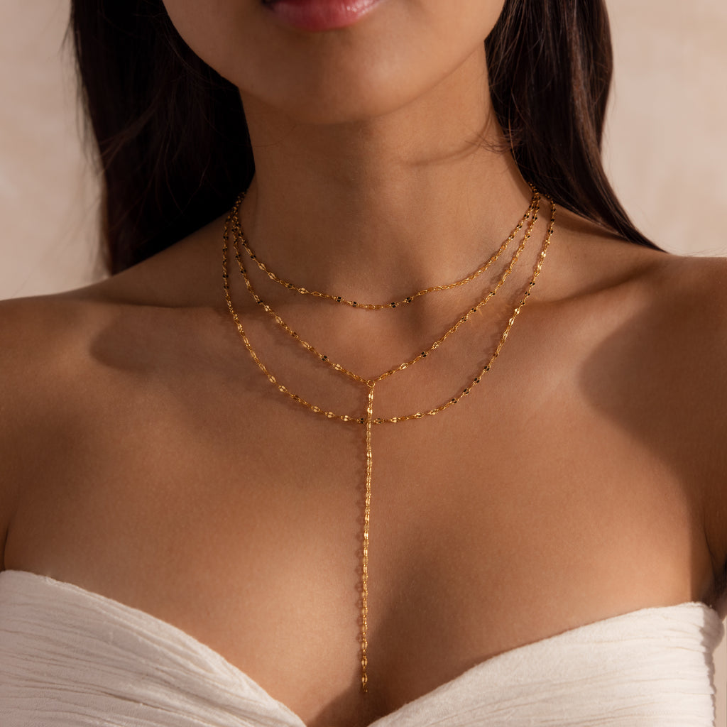 Model wearing a gold dainty Sparkling Layered Lariat Necklace, featuring 3 layers of mirror chain necklaces in varying lengths.