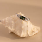 The silver agate ring is perched on a textured white seashell