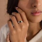 A woman gently touching her face while wearing the ring, showing how the piece sits elegantly on the hand. The deep green agate and clear baguettes catch soft light, offering a refined and natural look.