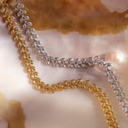 The Fishtail Chain Bracelet, featuring intricate craftsmanship and a cascading texture, is displayed on a marbled, pearlescent background.