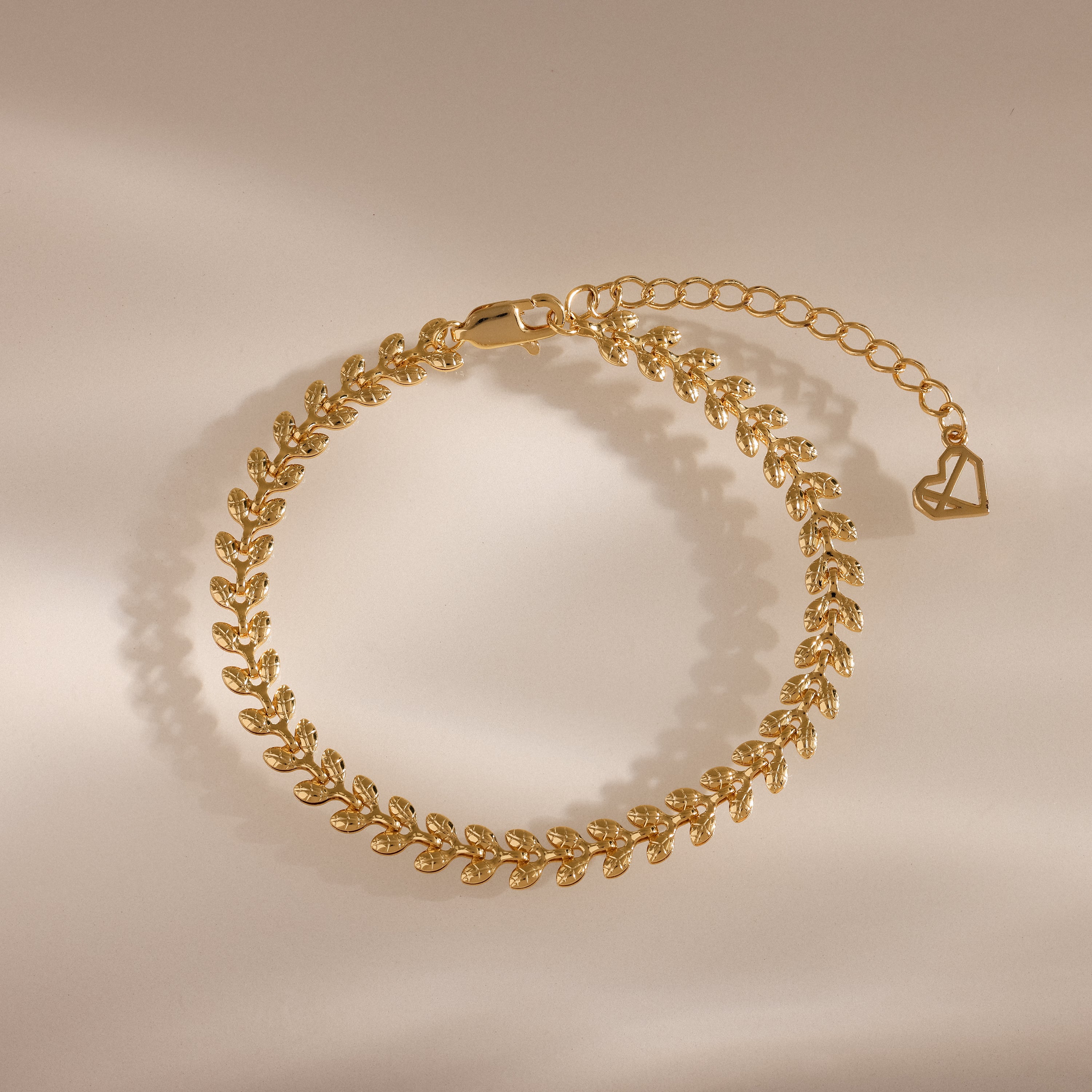 The Fishtail Chain Bracelet in 18K Gold features interwoven, leaf-shaped links and detailed craftsmanship with an adjustable clasp, displayed on a neutral background.