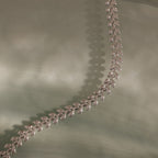 The Fishtail Chain Bracelet is displayed on a soft, light green surface.