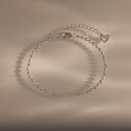 Dune Beaded Bracelet in Silver features polished silver beads, a heart charm, and an adjustable chain, displayed on a neutral background.