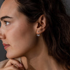 Woman with wavy brown hair wearing Starburst Cluster Ear Jackets in Sterling Silver, gazing thoughtfully to the left.
