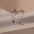 Agate Star Chain Earrings in Sterling Silver feature star-shaped studs, chain drops, and green agate gemstone pendants for a celestial look that dazzles against any neutral backdrop.