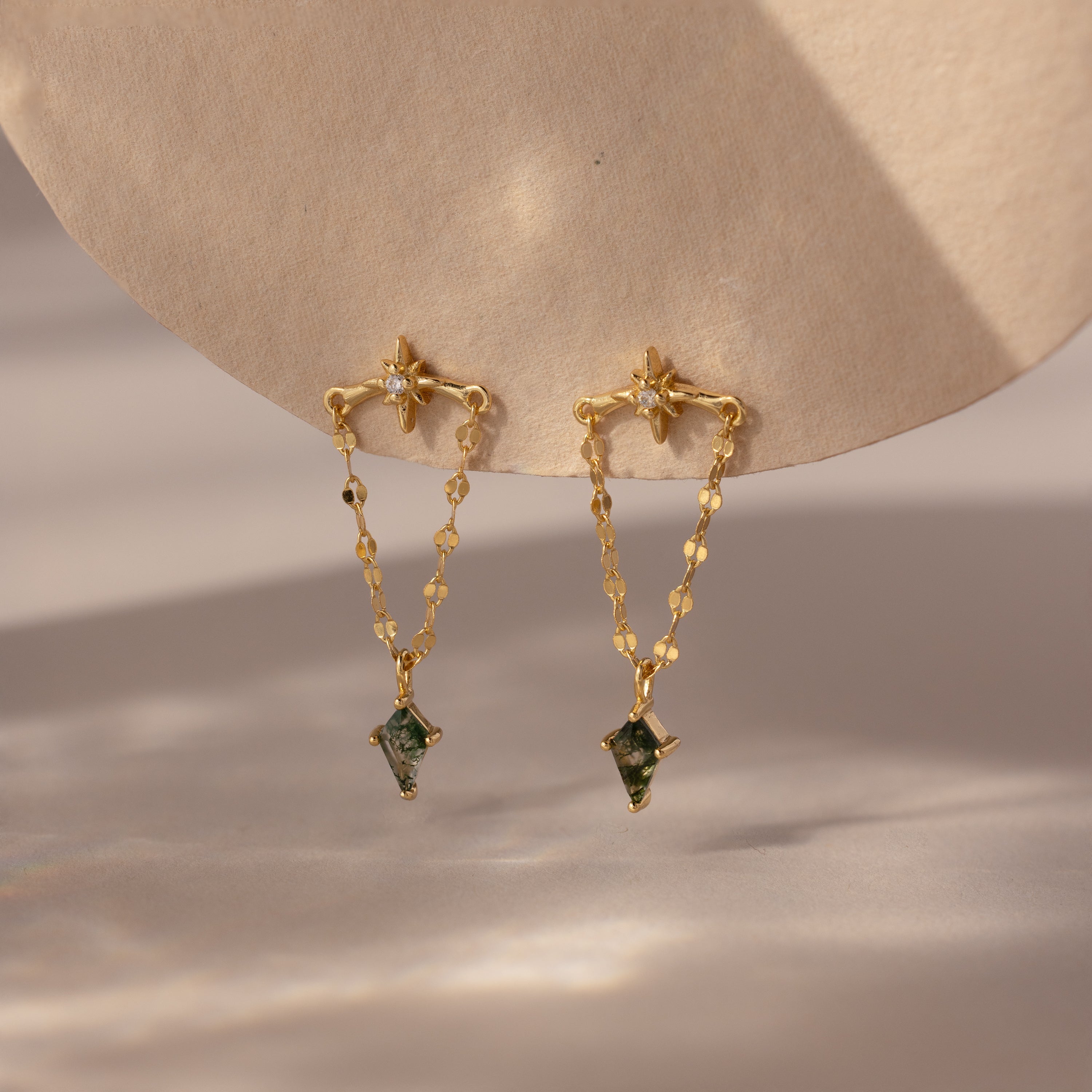 Agate Star Chain Earrings featuring double chains and green agate gemstone pendants, displayed on a beige textured surface.