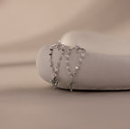 Agate Star Chain Earrings in Sterling Silver feature delicate chains and green agate star charms, displayed on a smooth stone—celestial earrings perfect for adding a whimsical touch.