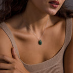 Woman wearing a knit beige top and the Celestial Jade Pendant Necklace, featuring a silver green gemstone and jade stone pendant.