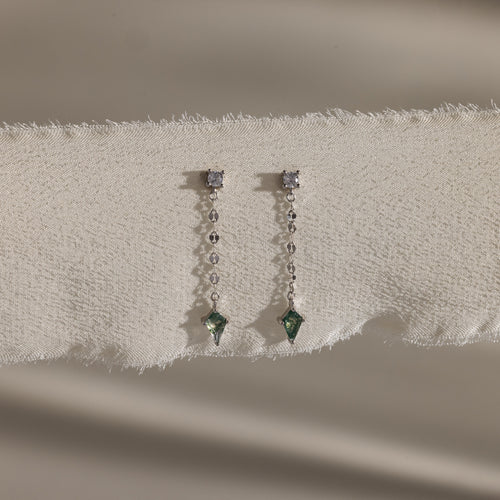 Agate Diamond Dangle Earrings in Sterling Silver, with faceted agate stones, diamonds, and green gemstones on a mirror chain, are elegantly displayed on textured cream fabric.
