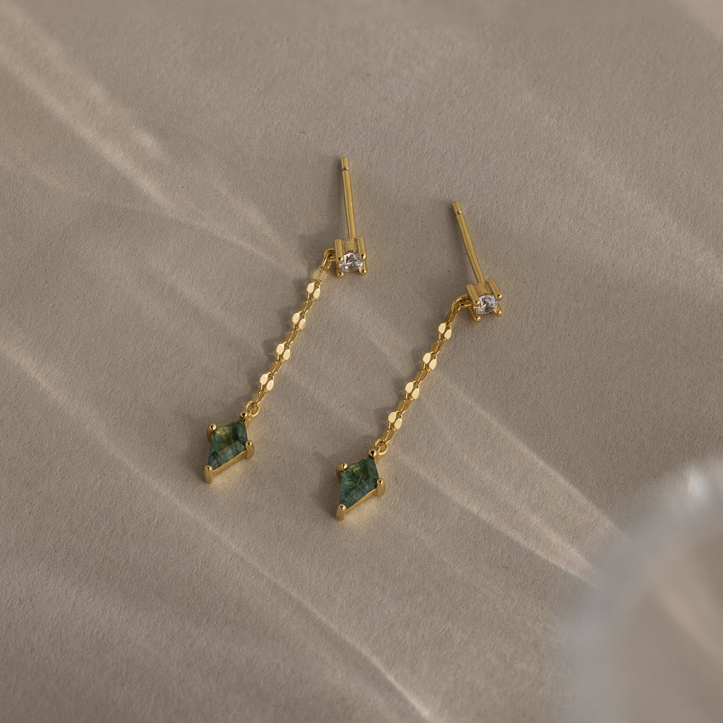 Agate Diamond Dangle Earrings in 18K Gold with faceted agate stones and clear accents, displayed on a neutral textured surface.