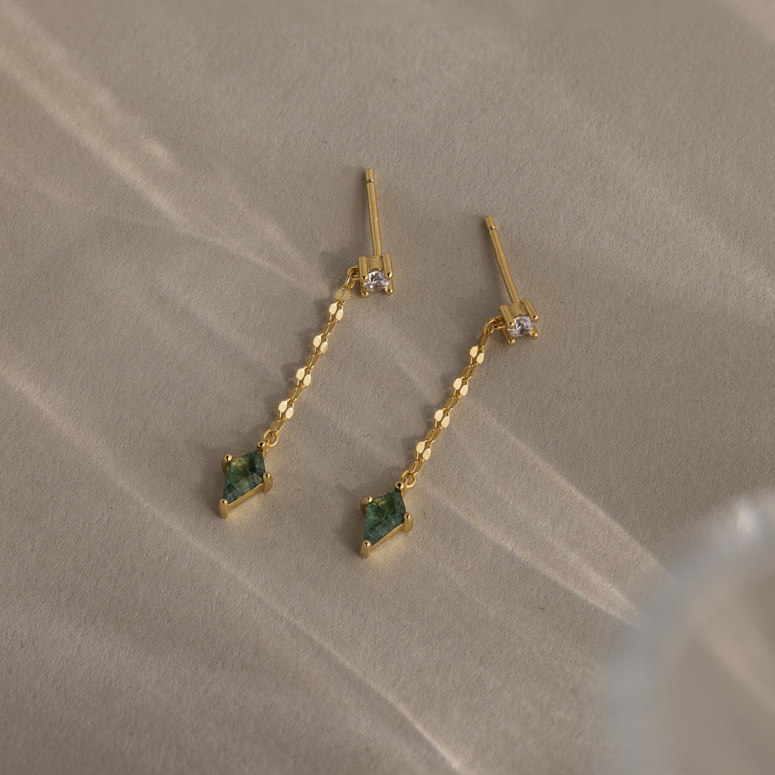 Agate Diamond Dangle Earrings in 18K Gold with faceted agate stones and clear accents, displayed on a neutral textured surface.