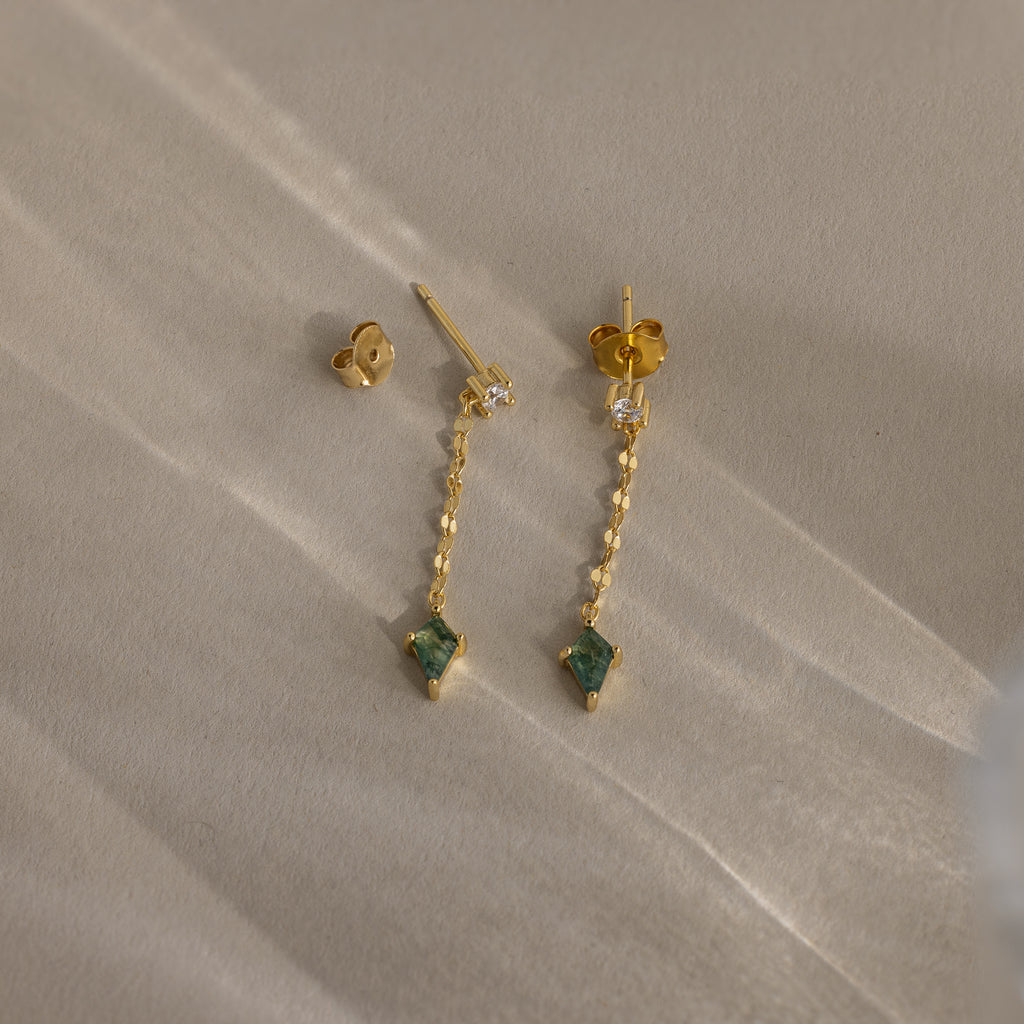 Agate Diamond Dangle Earrings in 18K Gold, featuring green faceted agate stones and separate earring backings, are displayed on a light, textured surface.