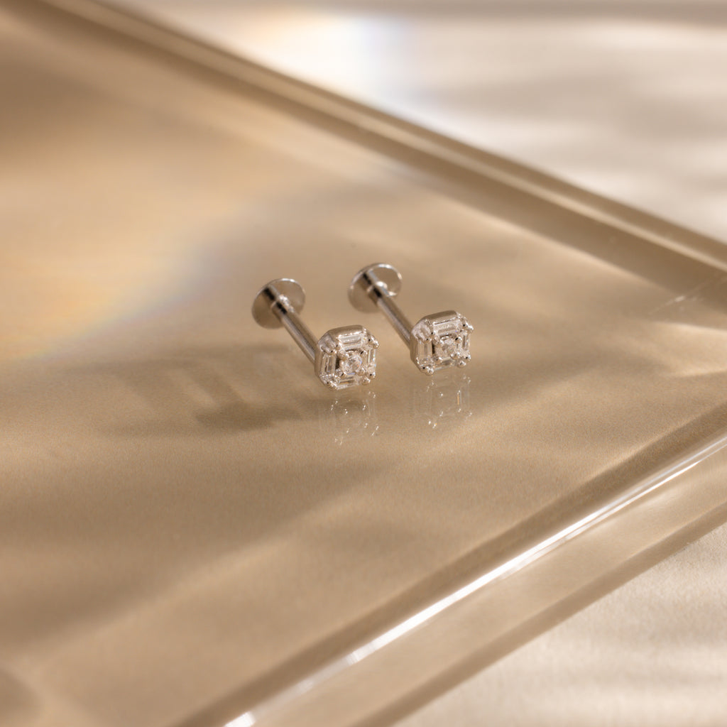 Pair of silver flatback earrings with vintage-inspired square diamond design on white marble.